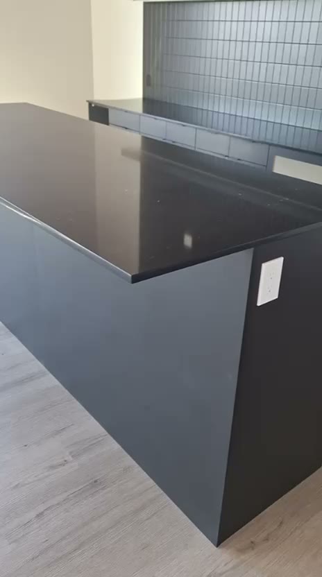 Video tour of a modern kitchen with a black quartz island and dark cabinetry