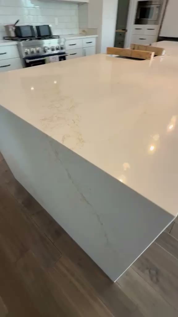 Video walkthrough of a white kitchen with a large quartz island