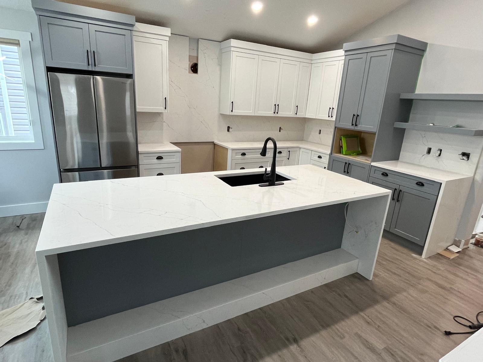 Angled view of a white quartz waterfall kitchen island