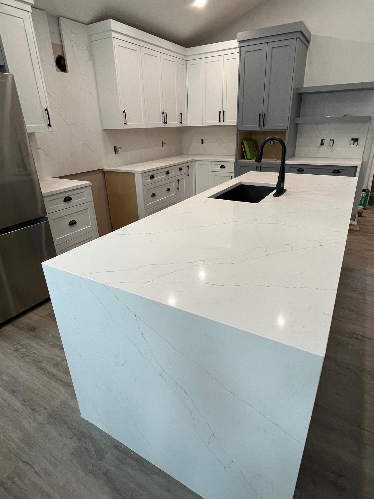Kitchen with a white quartz waterfall island