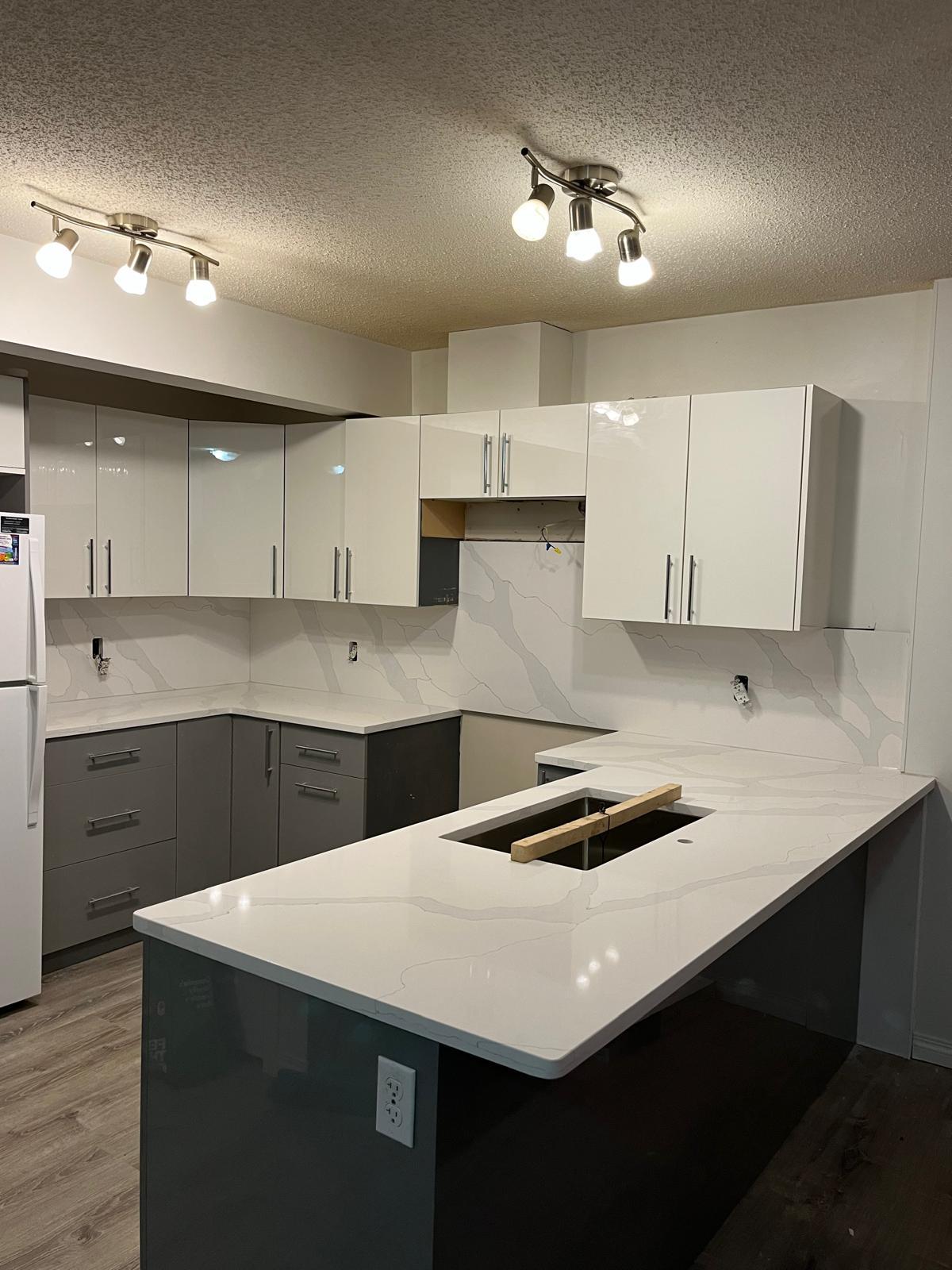 Kitchen with a full-height white quartz backsplash