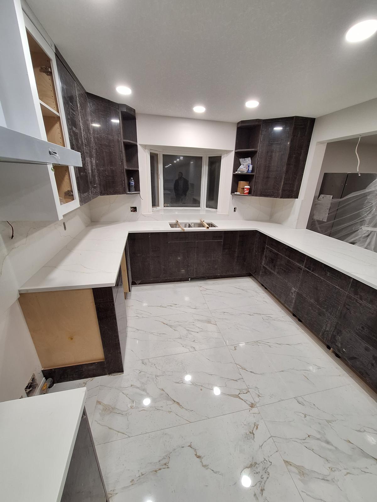 Kitchen with dark wood cabinets and white quartz countertops and island