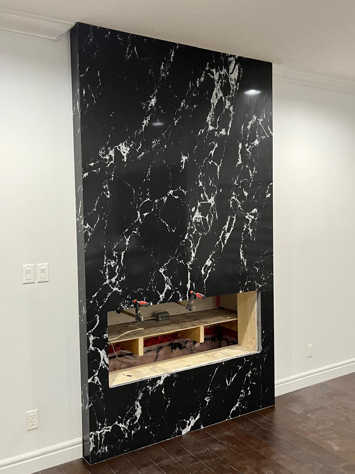 Angled view of a black marble fireplace feature wall