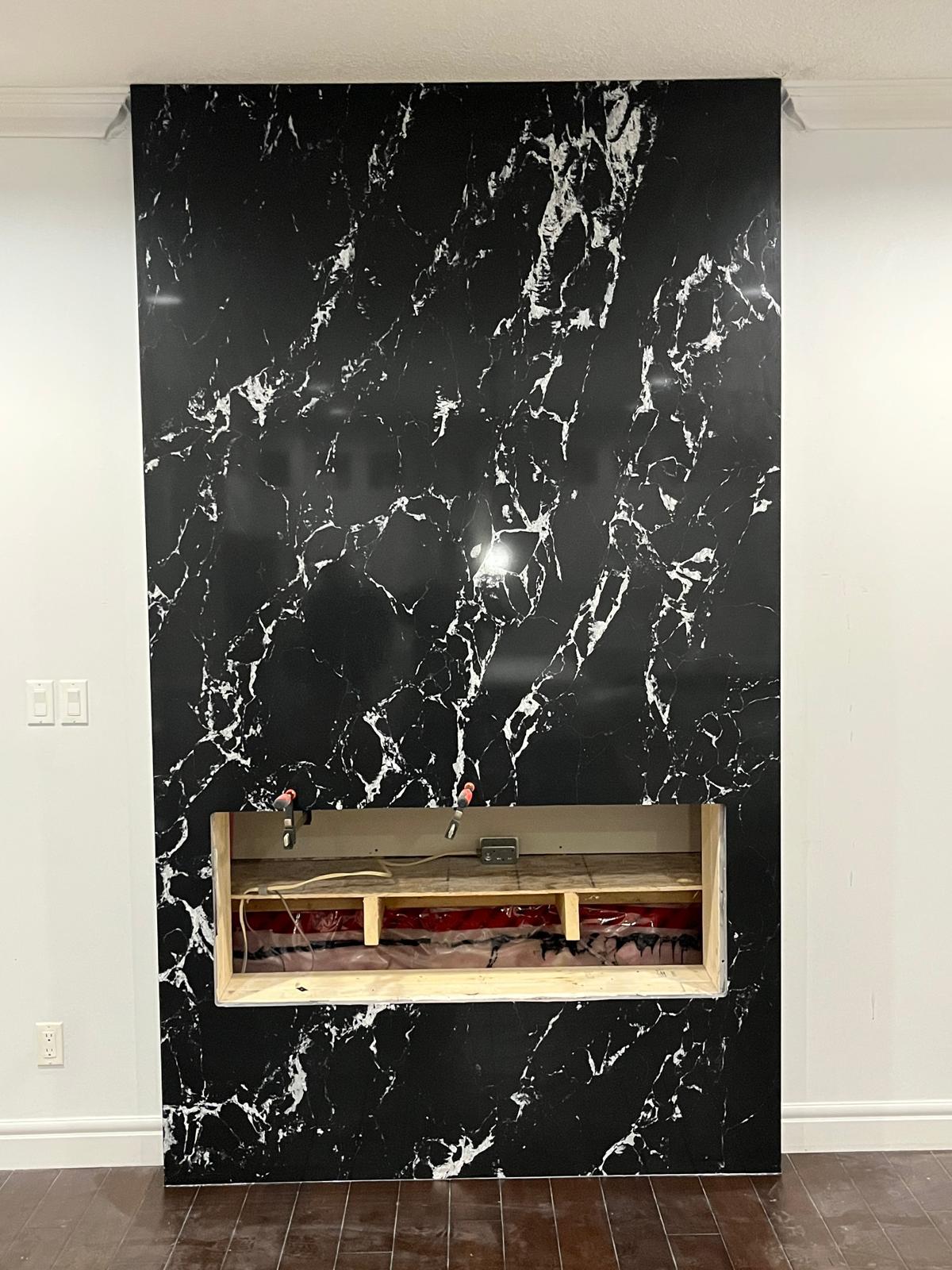 Dramatic black marble fireplace feature wall with open firebox cutout