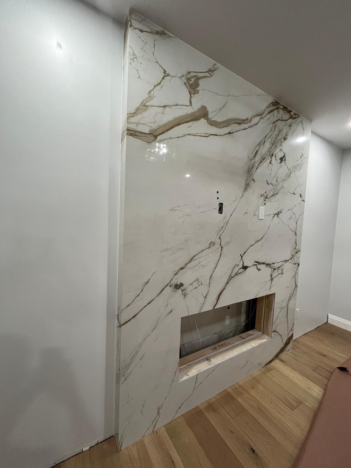 Side view of a full-height calacatta marble fireplace wall