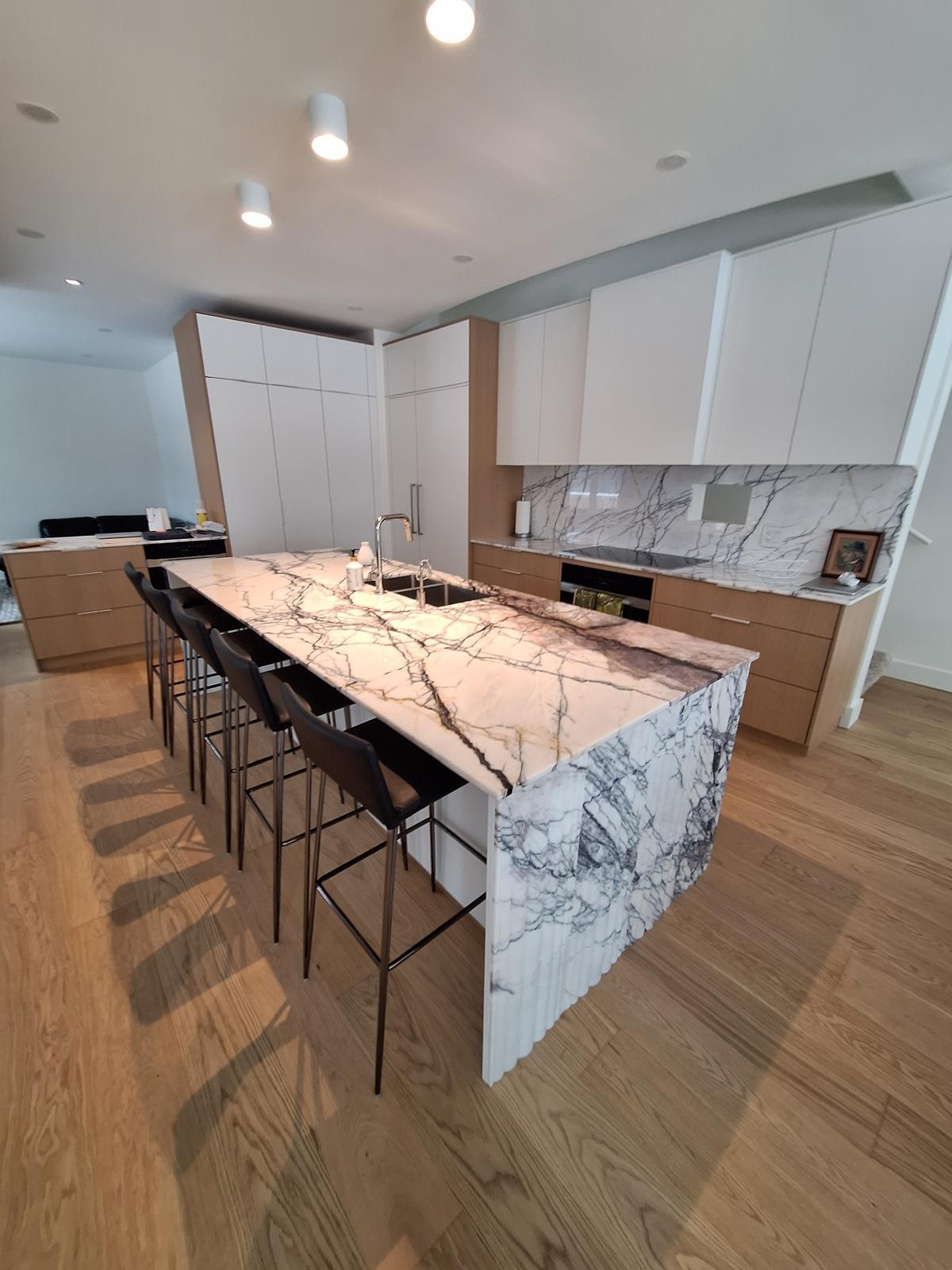 Kitchen with a full marble-look quartz waterfall island