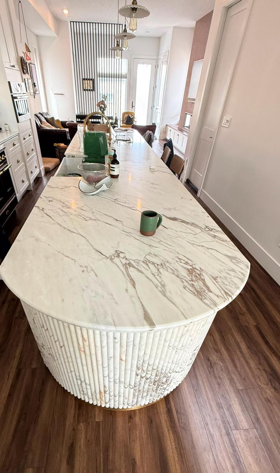 Kitchen with a rounded marble-look quartz island