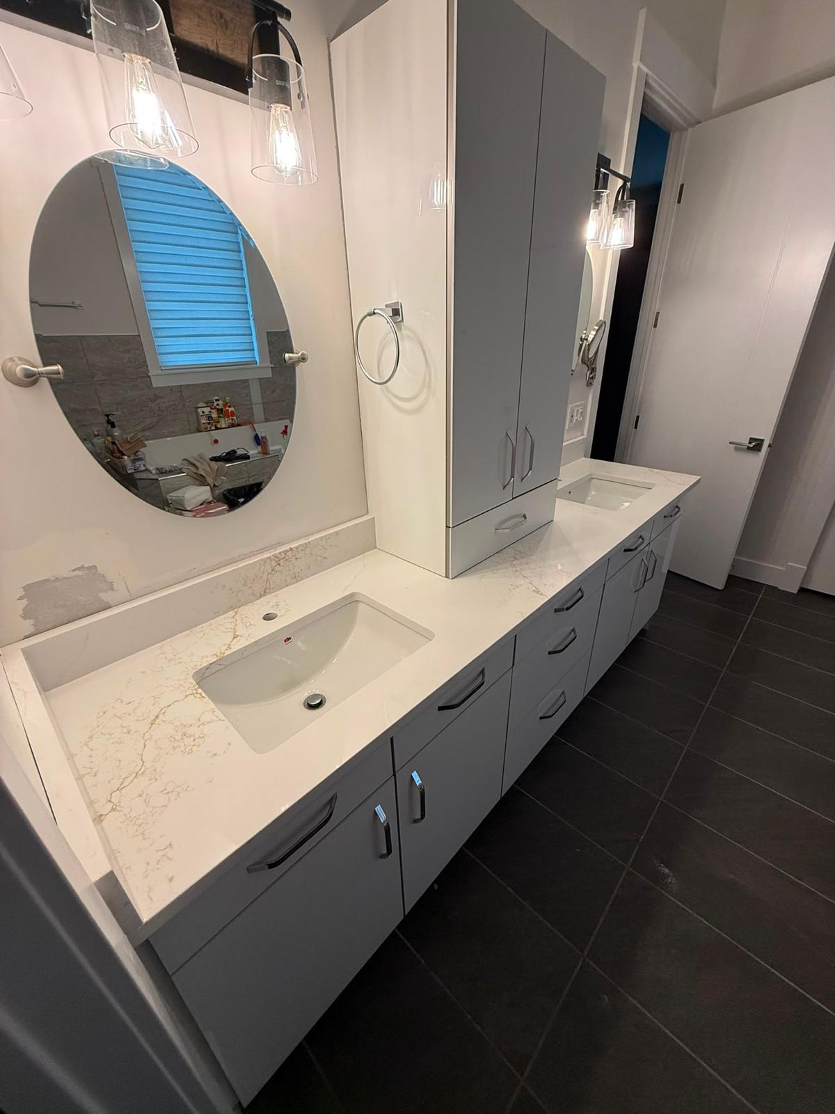 Left side view of a bathroom double vanity with stone countertop
