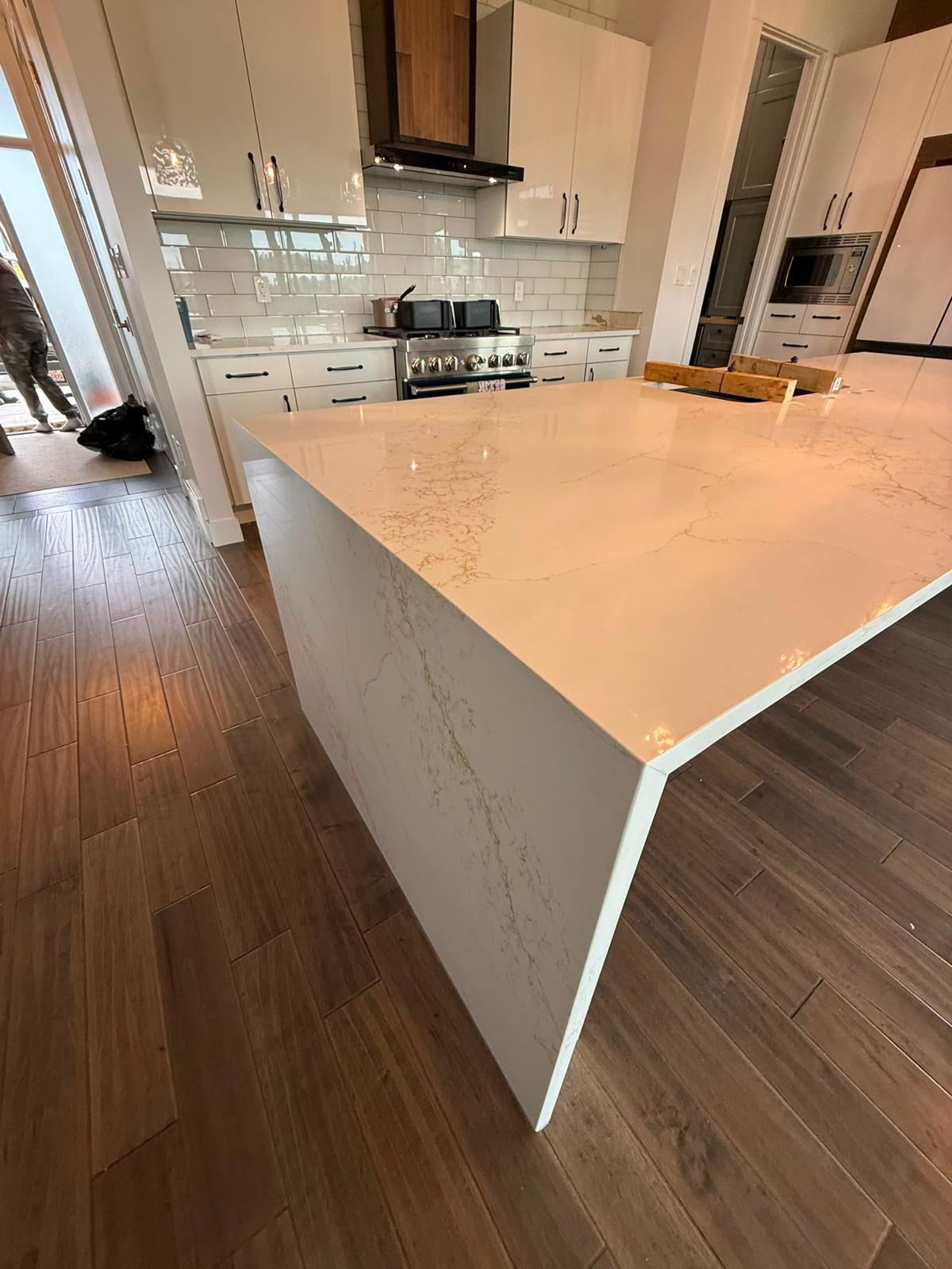 Left corner detail of a white quartz kitchen island