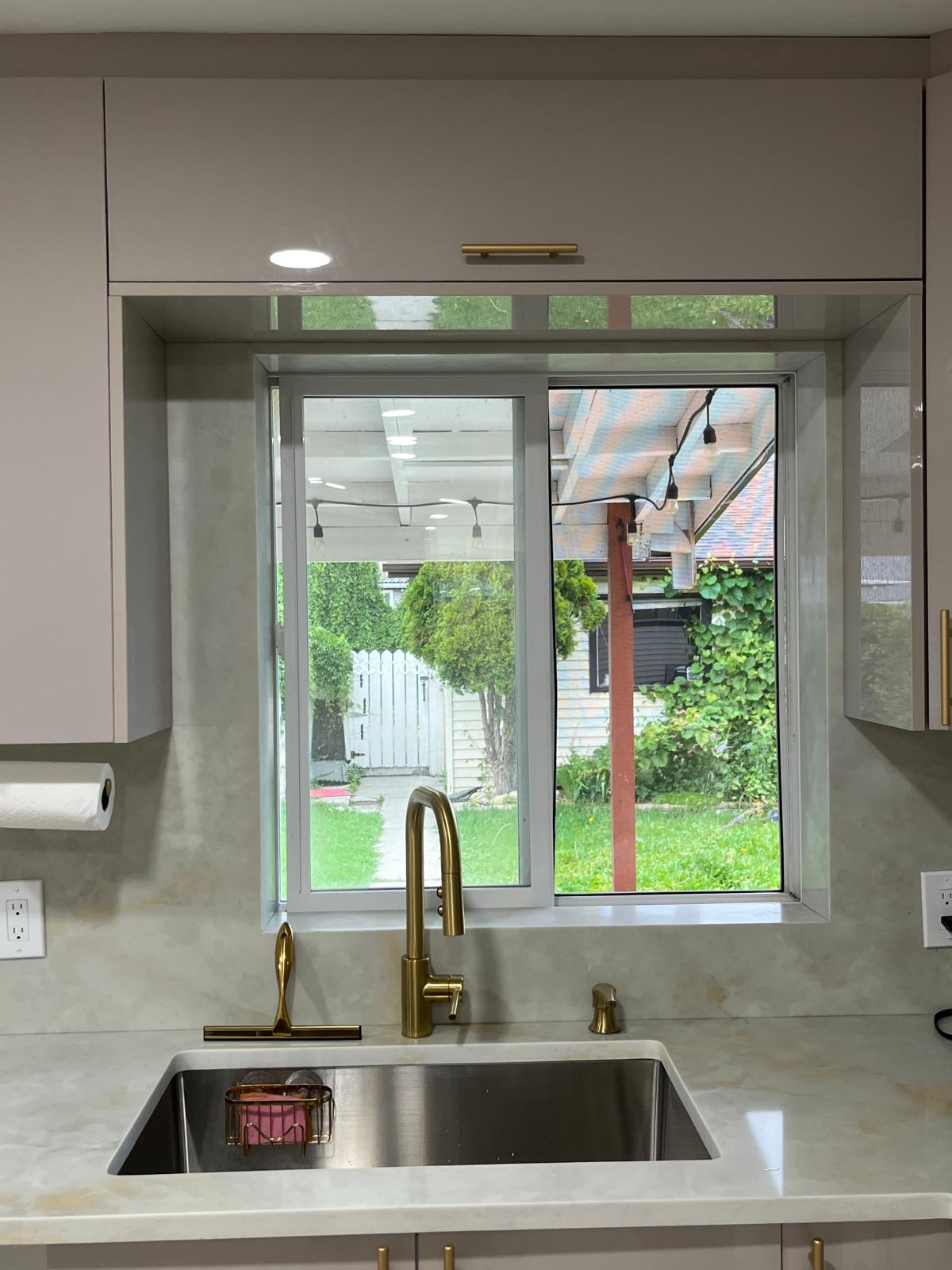 Close-up of a kitchen sink and stone backsplash