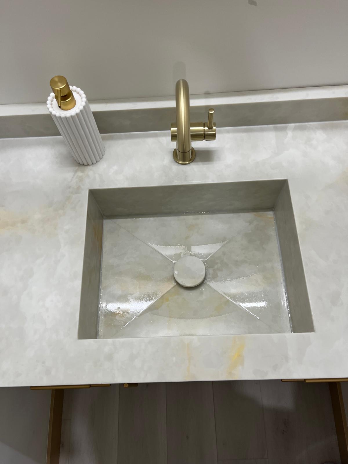 Close-up of a guest bathroom sink and stone countertop