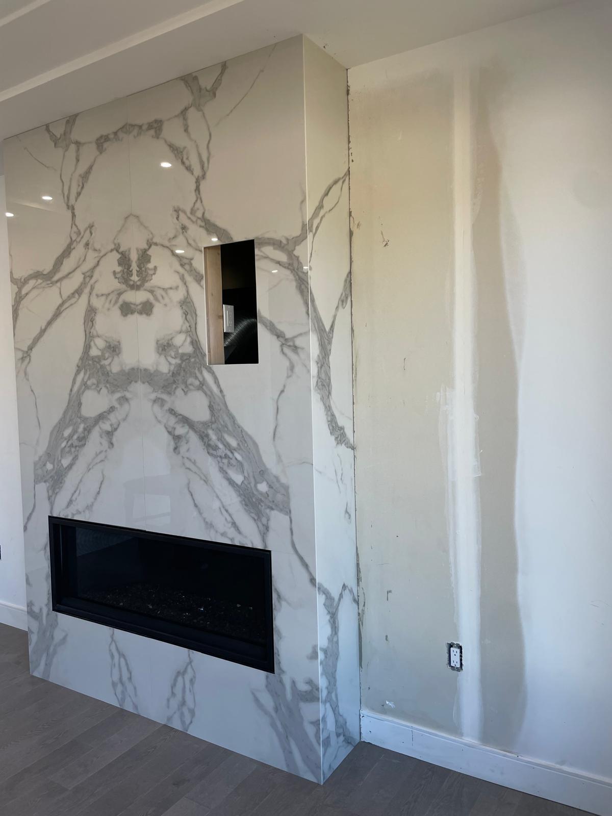 Side view of a bookmatched white marble fireplace feature wall and return